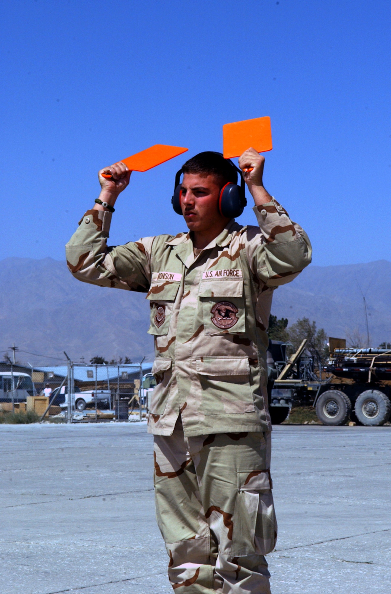 BAGRAM AIR BASE, Afghanistan -- Senior Airman George Bronson uses orange paddles to marshal a C-130 Hercules crew on the flightline here. Airman Bronson is a 455th Expeditionary Logistics Readiness Squadron transient-alert team member deployed from Little Rock AFB, Ark. The transient-alert Airmen handle an average of 14 aircraft each 12-hour shift. (U.S. Air Force photo by Master Sgt. Andrew Gates)