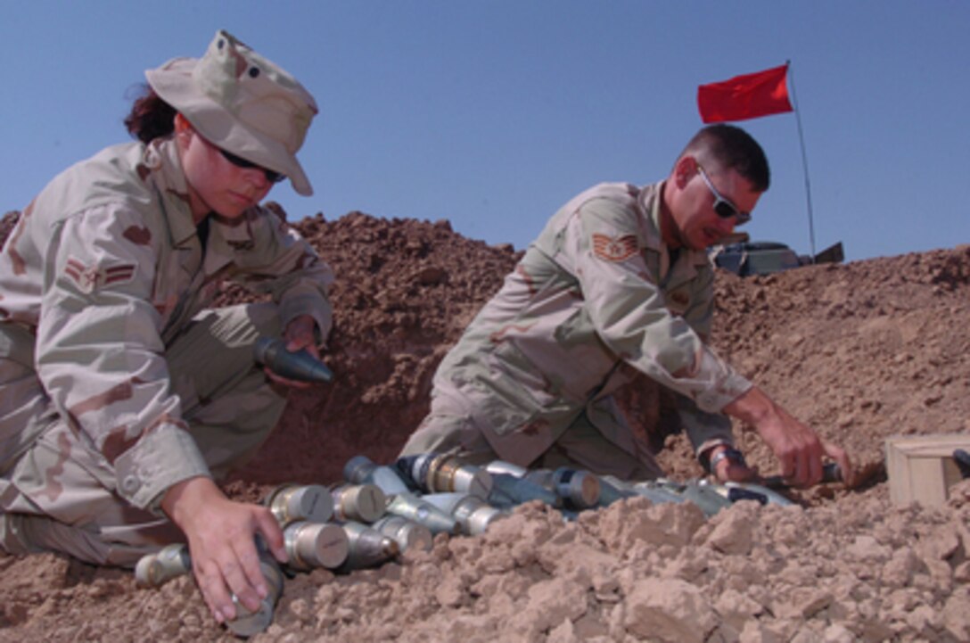Airman 1st Class Amber Weeks and Staff Sgt. Benjamin Kelly prepare ammunition fuses, flares and 50 caliber rounds for disposal on July 29, 2004. Weeks, attached to the 354th Civil Engineering Squadron at Eielson Air Force Base, Alaska, and Kelly, attached to the 39th Civil Engineering Squadron at Incirlik Air Base, Turkey, are both members of the Explosive Ordinance Disposal. 