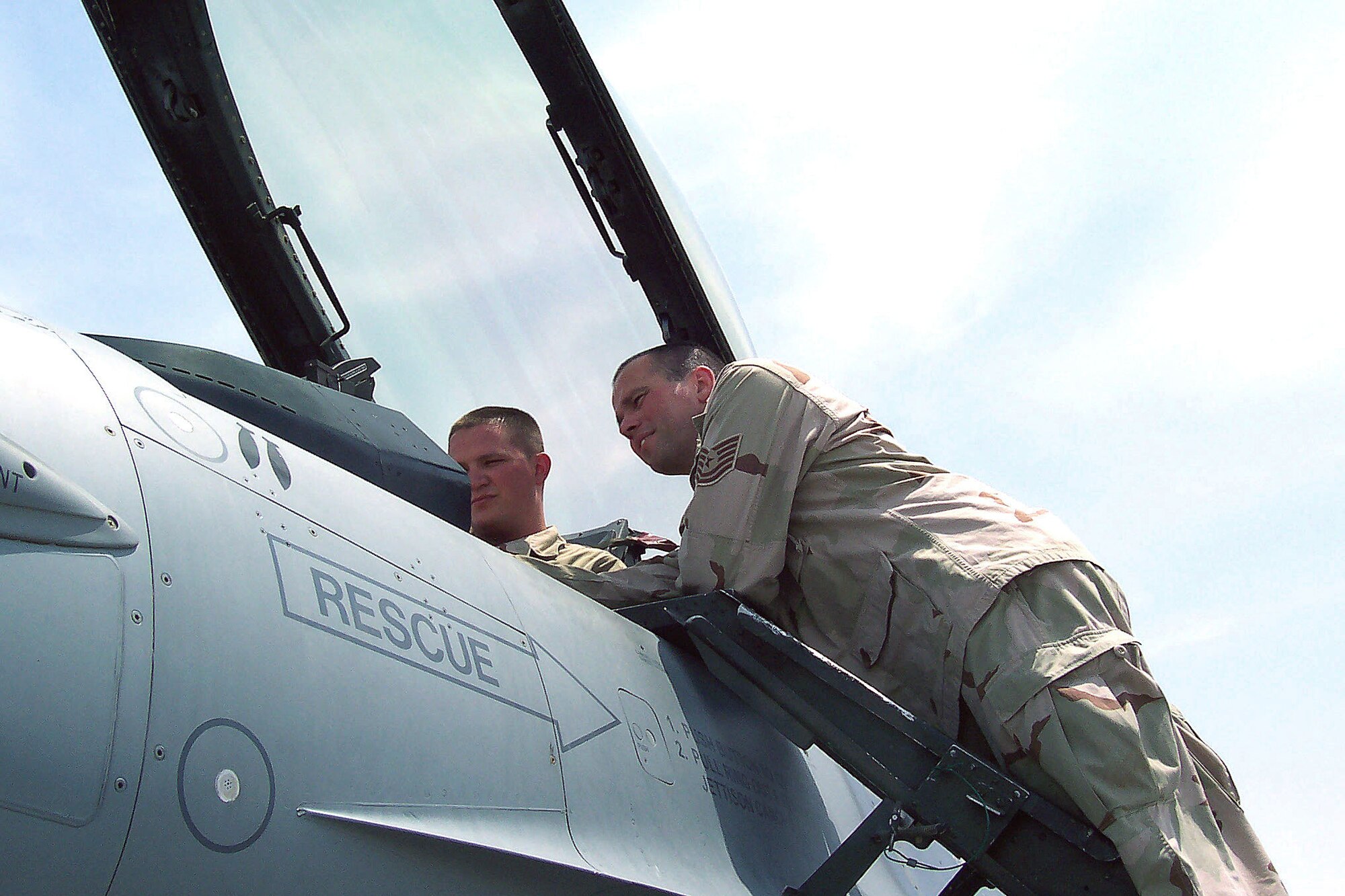 SOUTHWEST ASIA -- Tech. Sgt. James Kehoe (right) troubleshoots a discrepancy on an F-16C Fighting Falcon with his son, Senior Airman Travis Kehoe.  They are Airmen with the Vermont Air National Guard's 158th Fighter Wing.  The memory of Marine Cpl. Mark Evnin, a family friend who was killed in action last year, is what puts the fire in their fight.  (U.S. Air Force photo by Staff Sgt. Colleen Bushnell)  