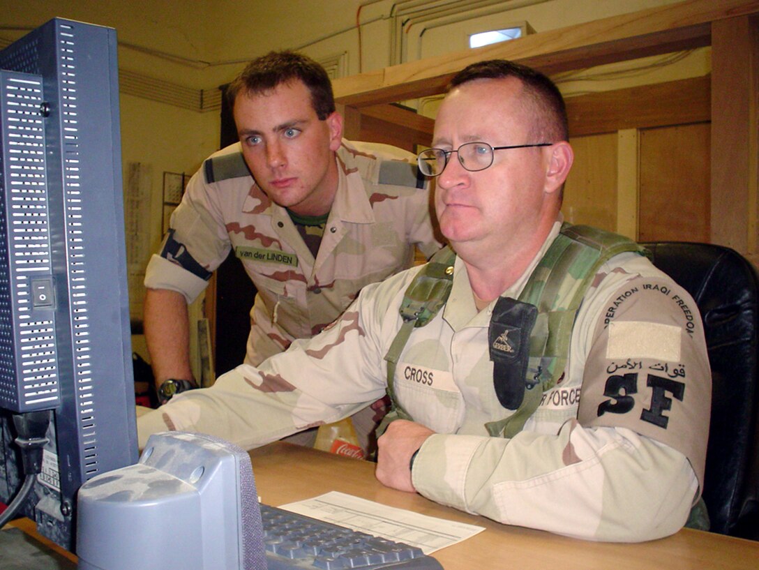TALLIL AIR BASE, Iraq -- Tech. Sgt. Keith Cross (right) works side-by-side with Dutch air force 2nd Lt. Bjorn van der Linden and other coalition forces in the Combined Defense Operations Center gathering information and formulating responses to threatening situations.  Sergeant Cross is the center's day-shift supervisor.  (U.S. Air Force photo by Master Sgt. Debbie Aragon)