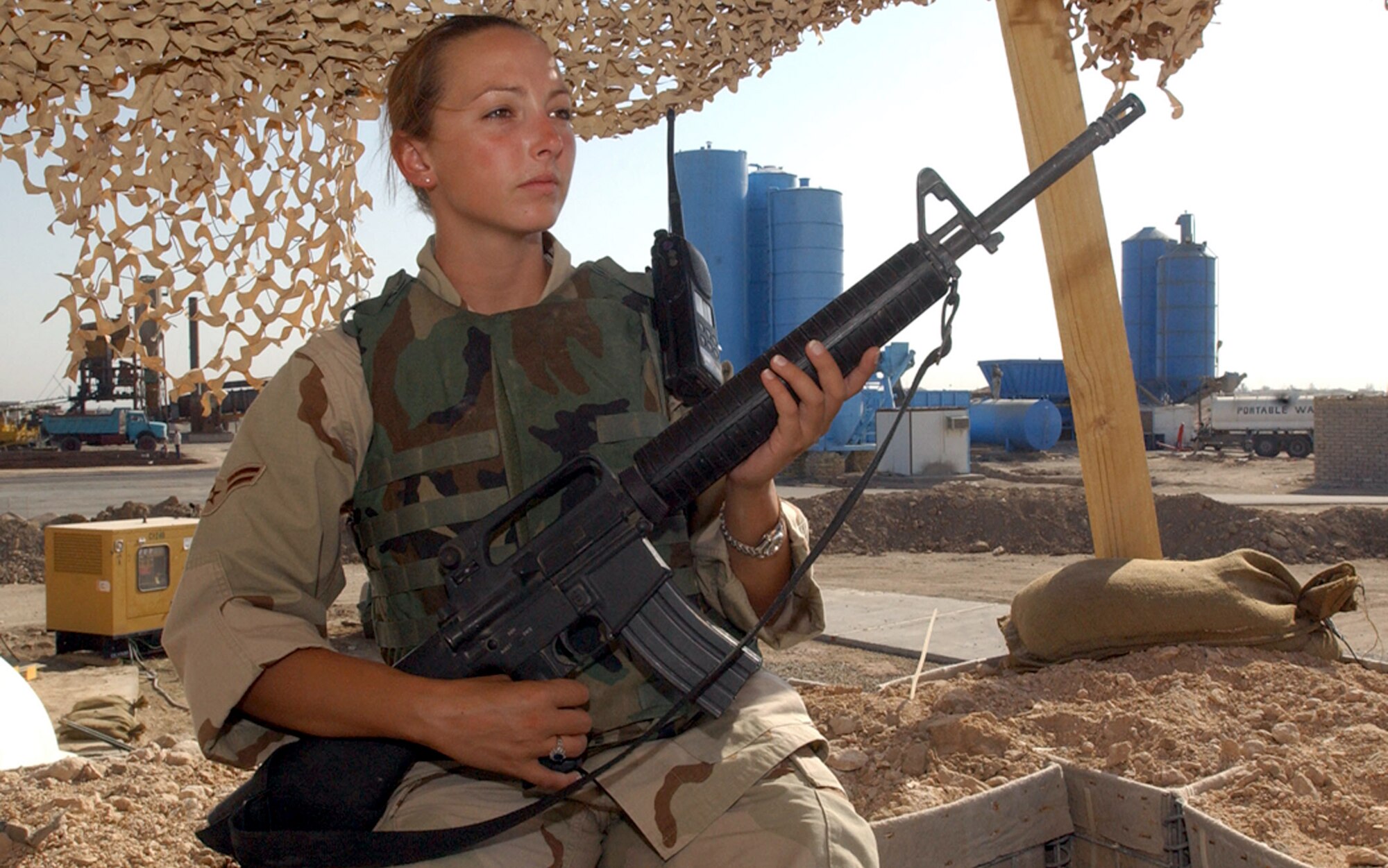 TALLIL AIR BASE, Iraq -- Airman 1st Class Caroline George watches local-national workers at the cement plant here.  She is one of about 50 Airmen deployed here to serve as an escort for the 407th Expeditionary Civil Engineer Squadron's force protection flight.  (U.S. Air Force photo by Staff Sgt. Craig Clapper)