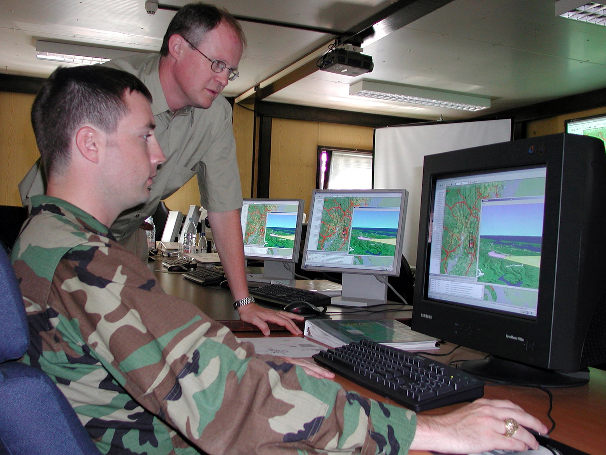 RAMSTEIN AIR BASE, Germany -- Capt. Mack Coker (foreground) learns how to use the Global Procedure Designer with the help of Iain Hammond, a systems engineer for MacDonald Dettwiler.  The GPD is a new software-based program providing terminal instrument procedures specialists with a better evaluation of obstacles and terrain in the arrival and departure path for aircraft.  Captain Coker is the air procedures flight commander for U.S. Air Forces in Europe.  (U.S. Air Force photo by Tech. Sgt. Mona Ferrell)  