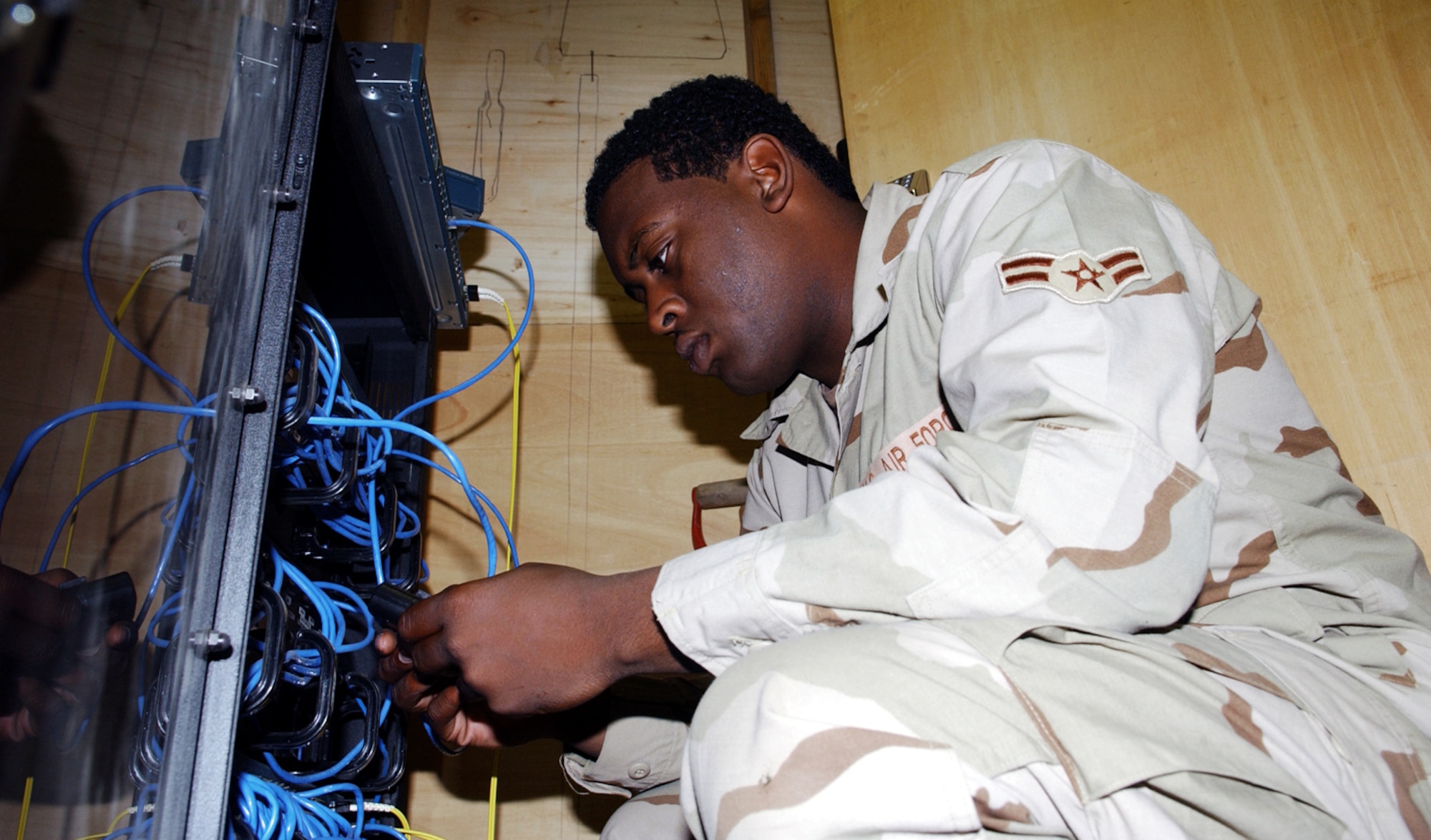 BAGRAM AIR BASE, Afghanistan -- Airman 1st Class Demetrill Newman tests a computer port here.  Airman Newman, an information manager with the 455th Expeditionary Support Squadron, does not normally get involved in the technical side of the computer network.  (U.S. Air Force photo by Master Sgt. Andrew Gates)
