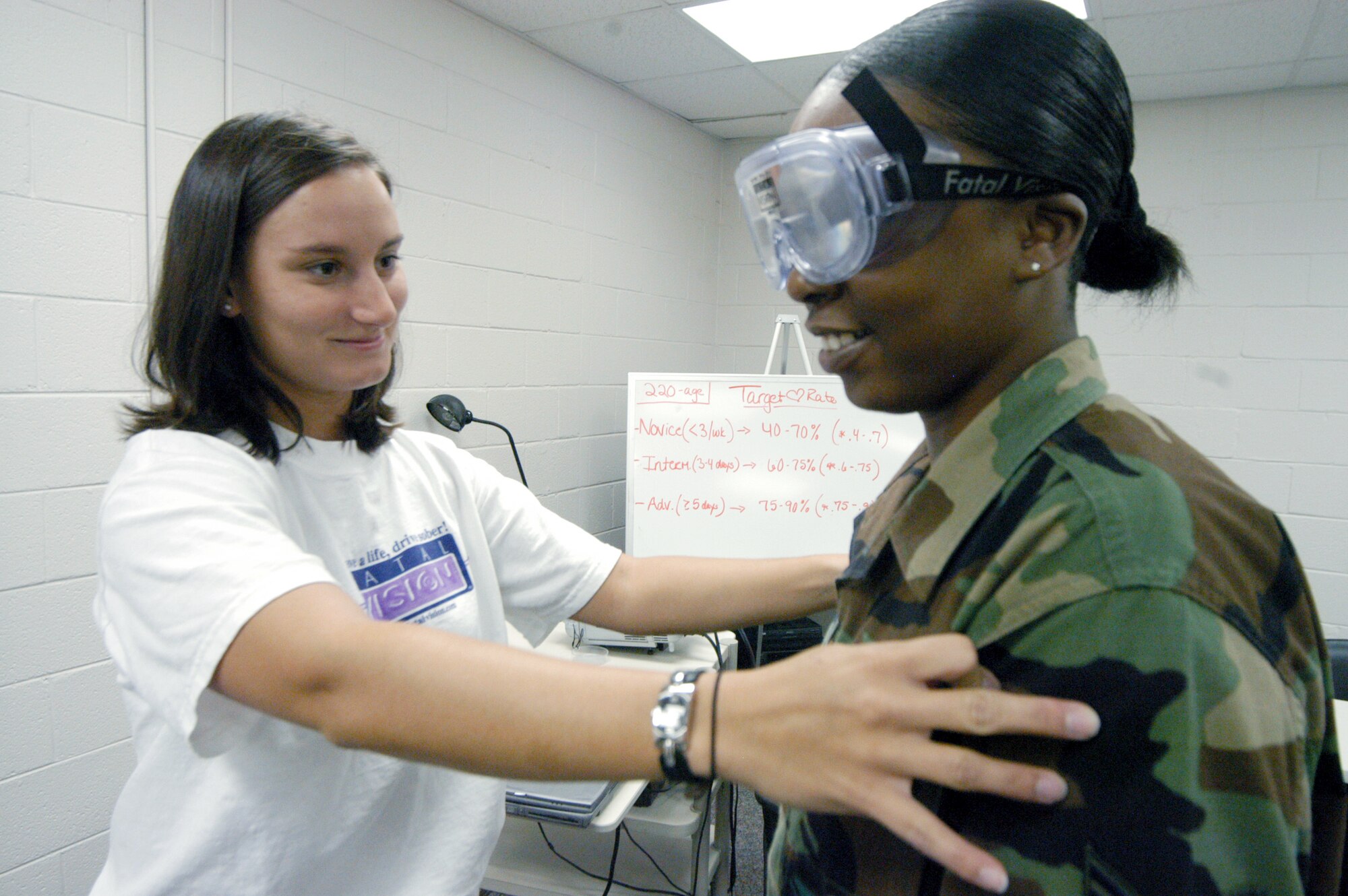 ROBINS AIR FORCE BASE, Ga. -- Tanya Paul helps Staff Sgt. Lacretia Wiseman try out the fatal-vision goggles.  The goggles can simulate vision at a blood alcohol content of 0.08 to 0.15 percent.  Ms. Paul is an intern at the health and wellness center here.  (U.S. Air Force photo by Sue Sapp)