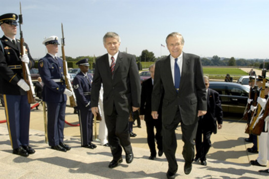 Secretary of Defense Donald H. Rumsfeld (right) escorts Polish Prime Minister Marek Belka through an honor cordon and into the Pentagon on Aug. 9, 2004. The two men will meet to discuss a range of security issues of mutual interest to both nations. 