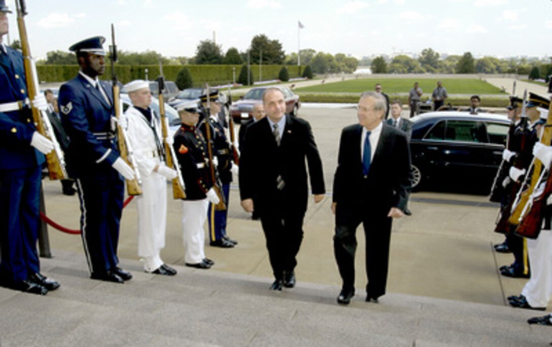 Secretary of Defense Donald H. Rumsfeld (right) escorts Danish Minister of Defense Soren Gade through an honor cordon and into the Pentagon on Aug. 9, 2004. The two defense leaders will meet to discuss a broad range of bilateral security issues. 