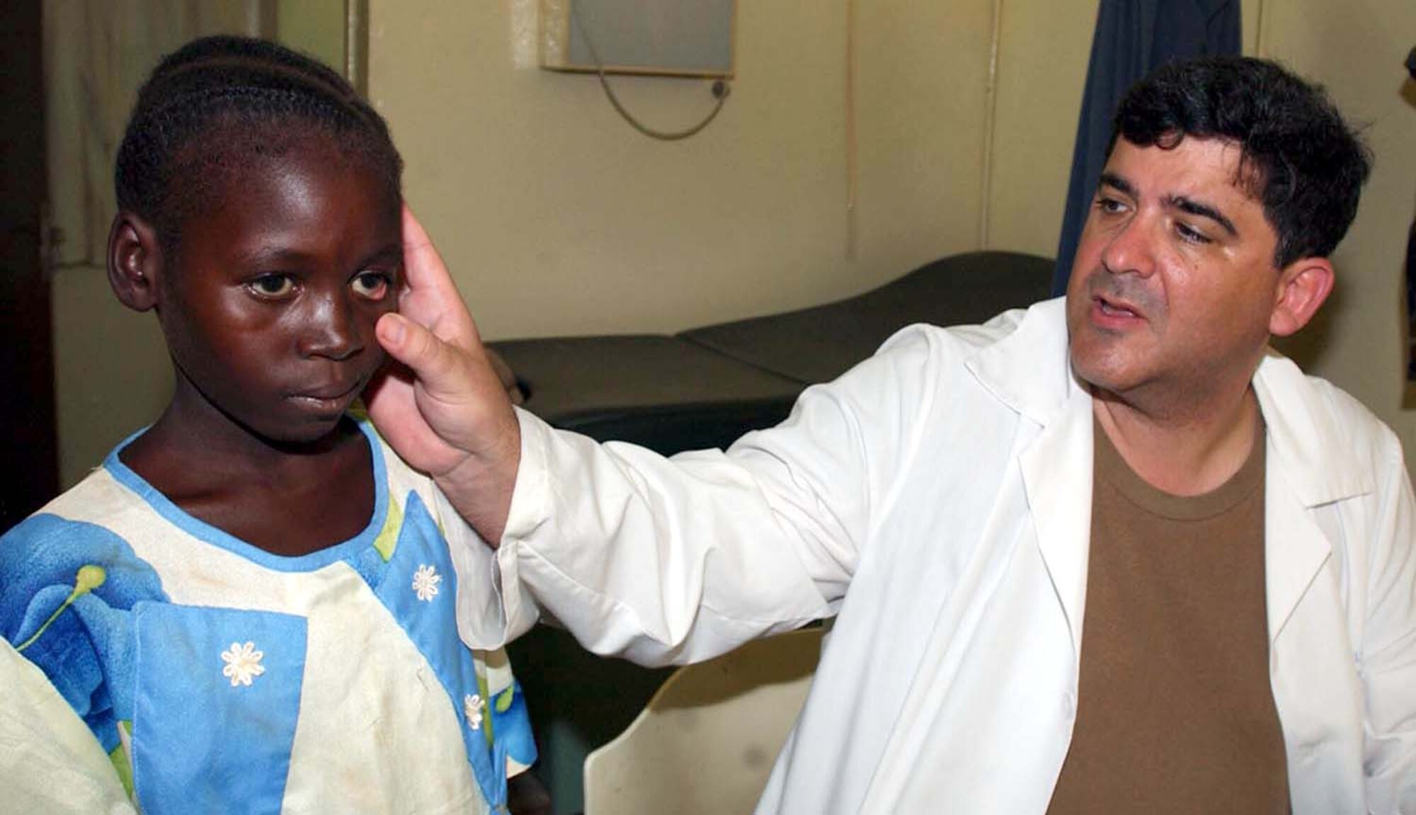CAMP TONDIBIAH, Niger -- Col. (Dr.) Omar Eaton checks a Nigerian girl's eye during a medical exam here.  Dr. Eaton is part of a 12-person Air Force Reserve Command medical team performing a humanitarian mission in Niger.  The doctor is an individual mobilization augmentee assigned to Andrews Air Force Base, Md.  (U.S. Air Force photo by Tech. Sgt. Chance Babin)