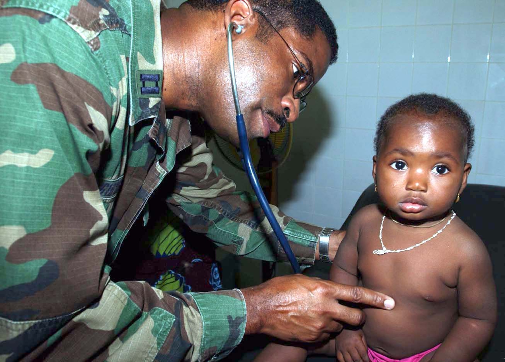 CAMP TONDIBIAH, Niger -- Capt. Andrew Gibson checks a Nigerian girl's health in a medical clinic here.  Captain Gibson is part of a 12-person Air Force Reserve Command medical team performing a humanitarian mission in Niger.  He is a physician's assistant assigned to the 6th Medical Group at MacDill Air Force Base, Fla.  (U.S. Air Force photo by Tech. Sgt. Chance Babin)