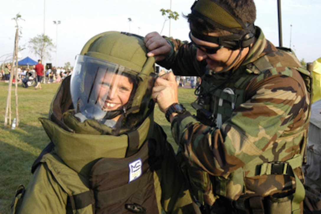 A young boy grins through the face shield of a helmet as he is fitted into an explosive ordnance disposal suit at the 21st Annual National Night Out event held at the Marinai Housing Community Center, Naval Air Station Sigonella, Sicily, on Aug. 3, 2004. Naval Air Station Sigonella provides logistics support for Commander, Sixth Fleet and North Atlantic Treaty Organization forces in the Mediterranean area of operation. 