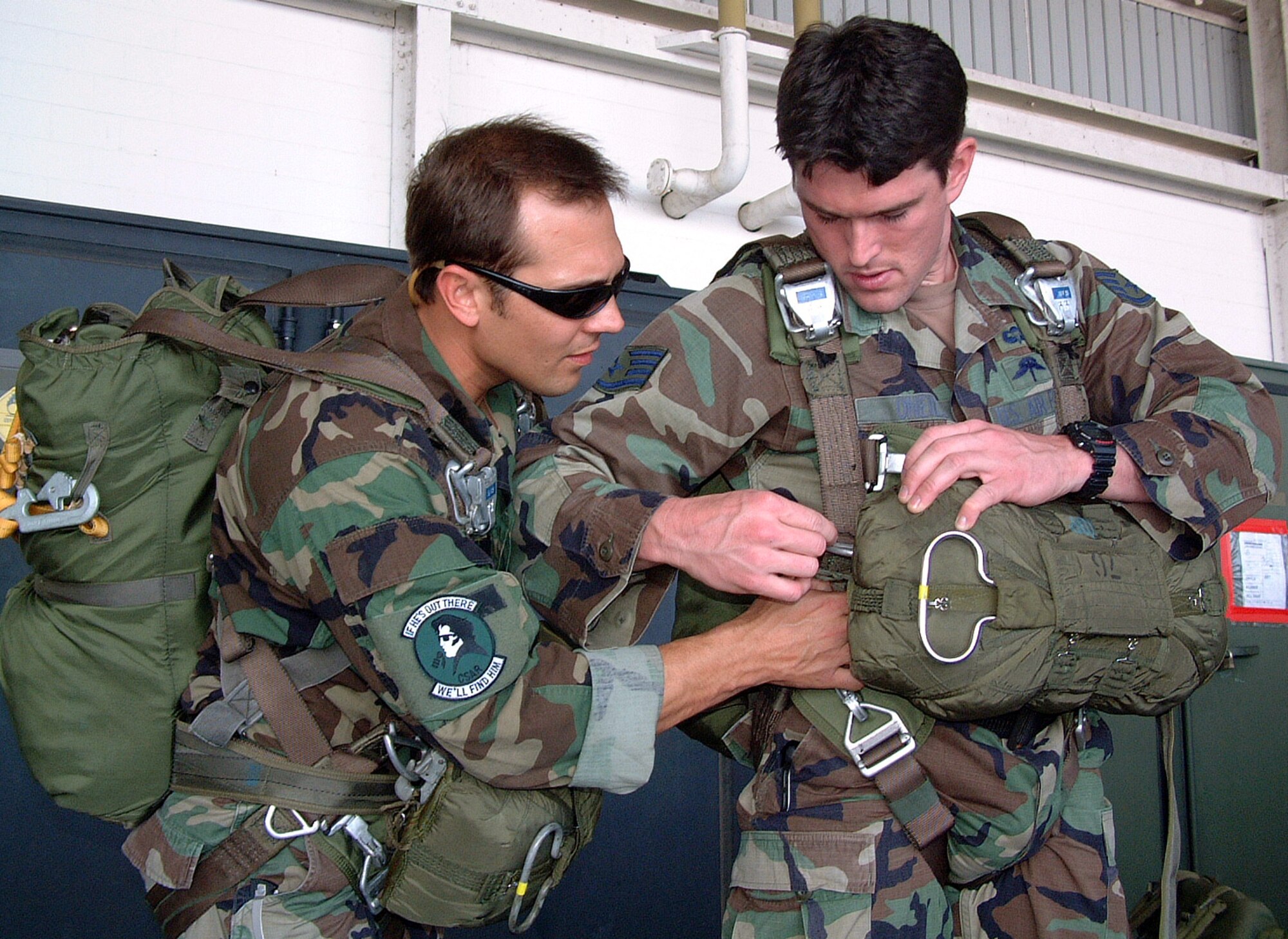CLARK AIR BASE, Philippines -- Staff Sgt. Nick (left) checks the parachute of Staff Sgt. Liam in a hangar at Clark Air Base, Philippines here Jan. 28. Nick is a pararescueman and Liam is a combat controller. Both are assigned to the 320th Special Tactics Squadron at Kadena Air Base, Japan. The squadron is in the Philippines for a monthlong joint combined exchange training program.  (U.S. Air Force photo by Master Sgt. Michael Farris)