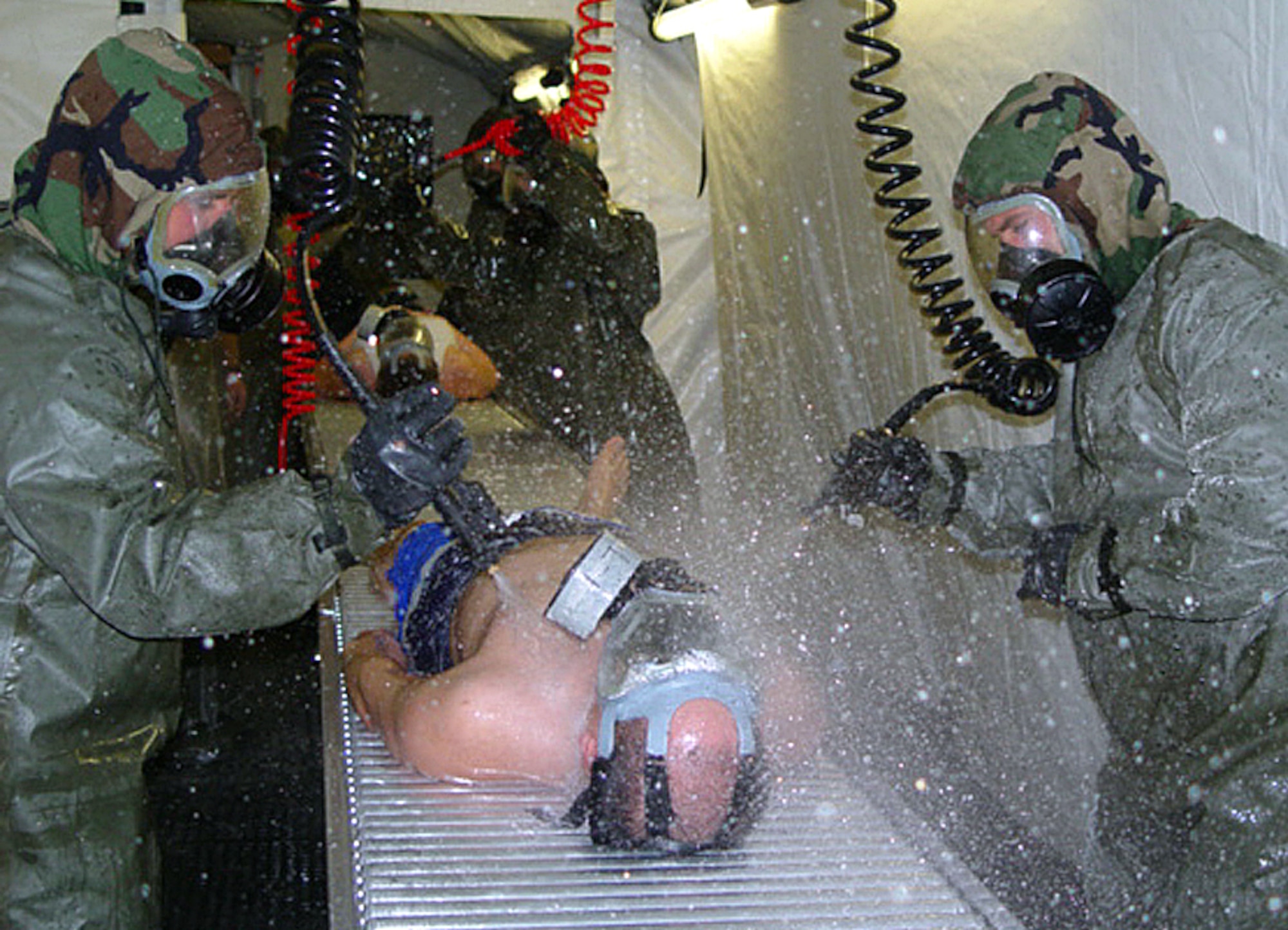 OSAN AIR BASE, South Korea -- Airman 1st Class Steven Randolph (left) and Senior Airman Roger Richards decontaminate a patient processing through the small shelter patient decontamination system. Both airmen are assigned to the 51st Medical Group. (U.S. Air Force photo by 1st Lt. Toni Tones)