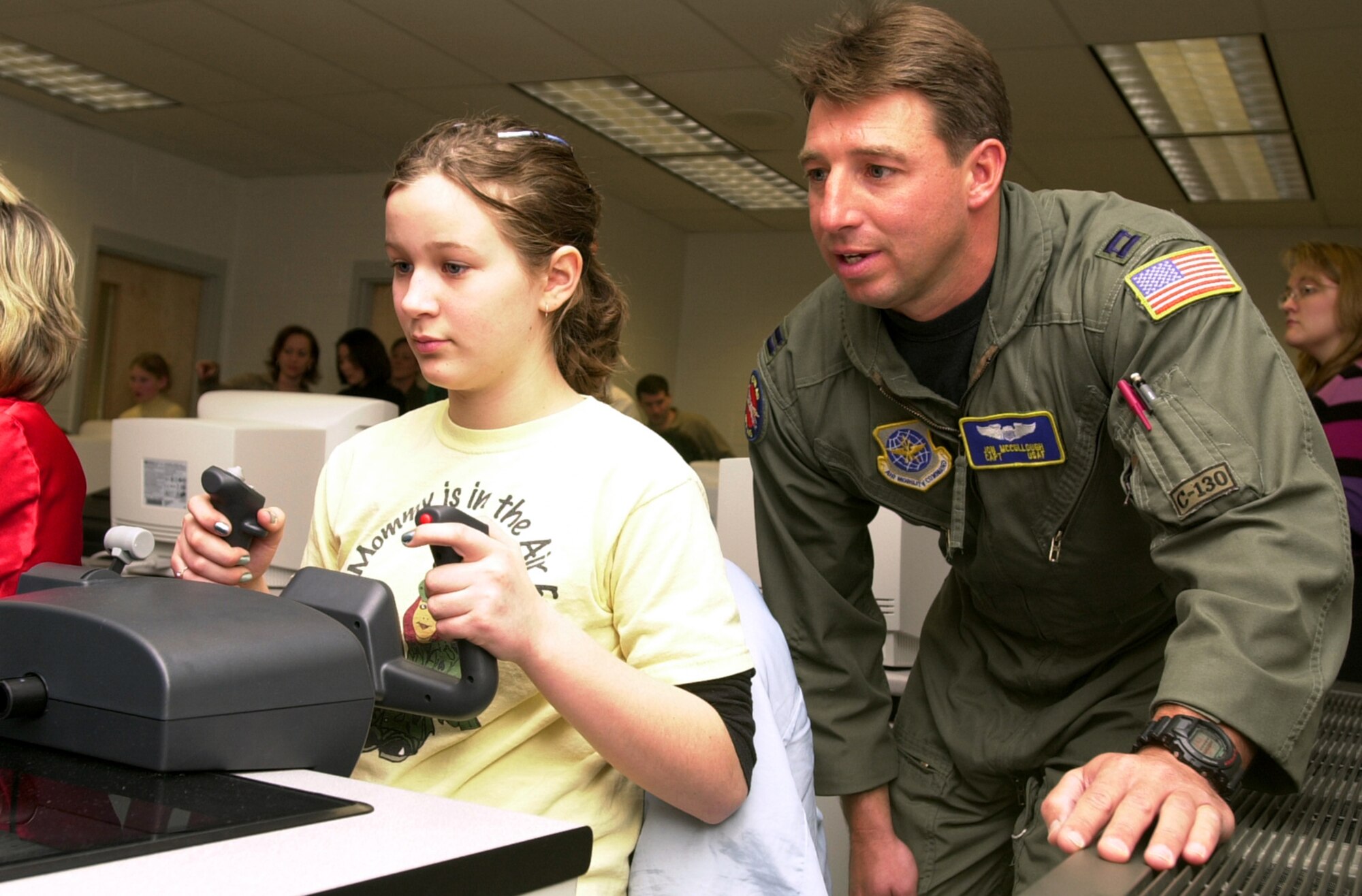 MARTINSBURG, W.Va. (AFPN) -- Fifth-grader Catherine Newcome, at the yoke, gets a feel for flying a small plane on a computer simulator during a National Guard Starbase exercise in Martinsburg, W.Va. Capt. Jon McCullough, a C-130 Hercules pilot in the West Virginia Air National Guard, offers some helpful hints while watching her progress. (U.S. Air Force photo by Master Sgt. Bob Haskell)