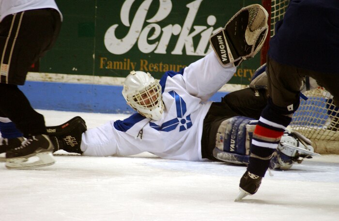 CHARLESTON AIR FORCE BASE, S.C. (AFPN) -- Air Force goalie Jeramie Banks hits the ice for a save against a Navy skater in the third period of an exhibition hockey game held Feb. 8 at the North Charleston Coliseum. Banks shut down the Navy for the first two periods, allowing only one goal. The third period heated up, but the Air Force team held on to win the match 8-6. The game was part of the South Carolina Stingrays Military Appreciation Night honoring those serving their country. Charleston-based servicemembers made up the teams.  (U.S. Air Force photo by Airman 1st Class Jason Bailey)