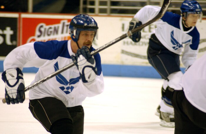 CHARLESTON AIR FORCE BASE, S.C. (AFPN) -- Karl Nichols races to beat a Navy player to a loose puck during an exhibition hockey game held Feb. 8 at the North Charleston Coliseum. Nichols helped lead the Air Force team to an 8-6 victory, scoring two goals and an assist. The game was part of the South Carolina Stingrays Military Appreciation Night honoring those serving their country. Charleston-based servicemembers made up the teams.  (U.S. Air Force photo by Airman 1st Class Jason Bailey)
