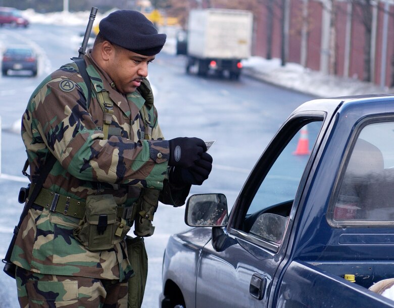 WASHINGTON -- A soldier from the Army National Guard's 276th Military Police Company in Washington checks identification at Bolling Air Force Base, D.C., on Feb. 21. Up to 10,000 soldiers will help secure Air Force installations worldwide while the Air Force phases in plans to beef up its own security forces. (U.S. Air Force photo by Tech. Sgt.  Jim Varhegyi)