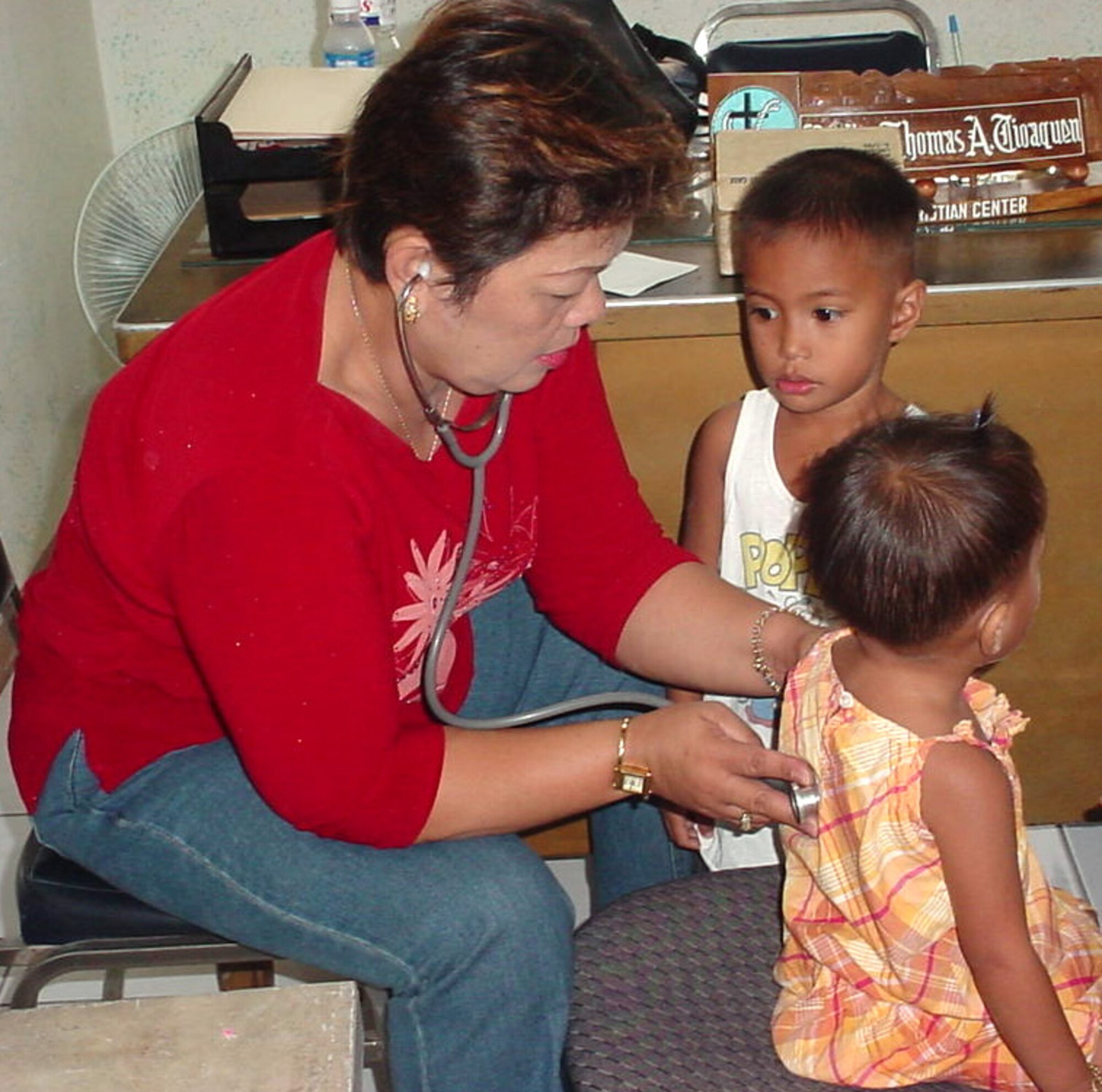 CLARK AIR BASE, Philippines  --  A doctor examines children at the Clarkview Christian Center in the Philippines. In a goodwill effort, members of the 353rd Maintenance Squadron from Kadena Air Base, Japan, hired a dentist, two doctors and a nurse to visit the center for a full day.  (U.S. Air Force photo by Master Sgt. Val Gempis)