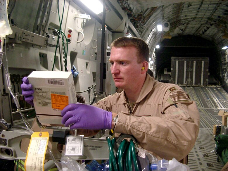 OPERATION SOUTHERN WATCH -- Capt. Paul Simpson fixes an IV fluid pump aboard an aerovac mission. Besides providing patient care, aeromedical evacuation crews must maintain and operate a variety of medical equipment before and throughout each mission. Simpson is a second flight nurse deployed with the 320th Expeditionary Aeromedical Evacuation Squadron/Forward from the 375th Aeromedical Evacuation Squadron at Scott Air Force Base, Ill. (Courtesy photo)