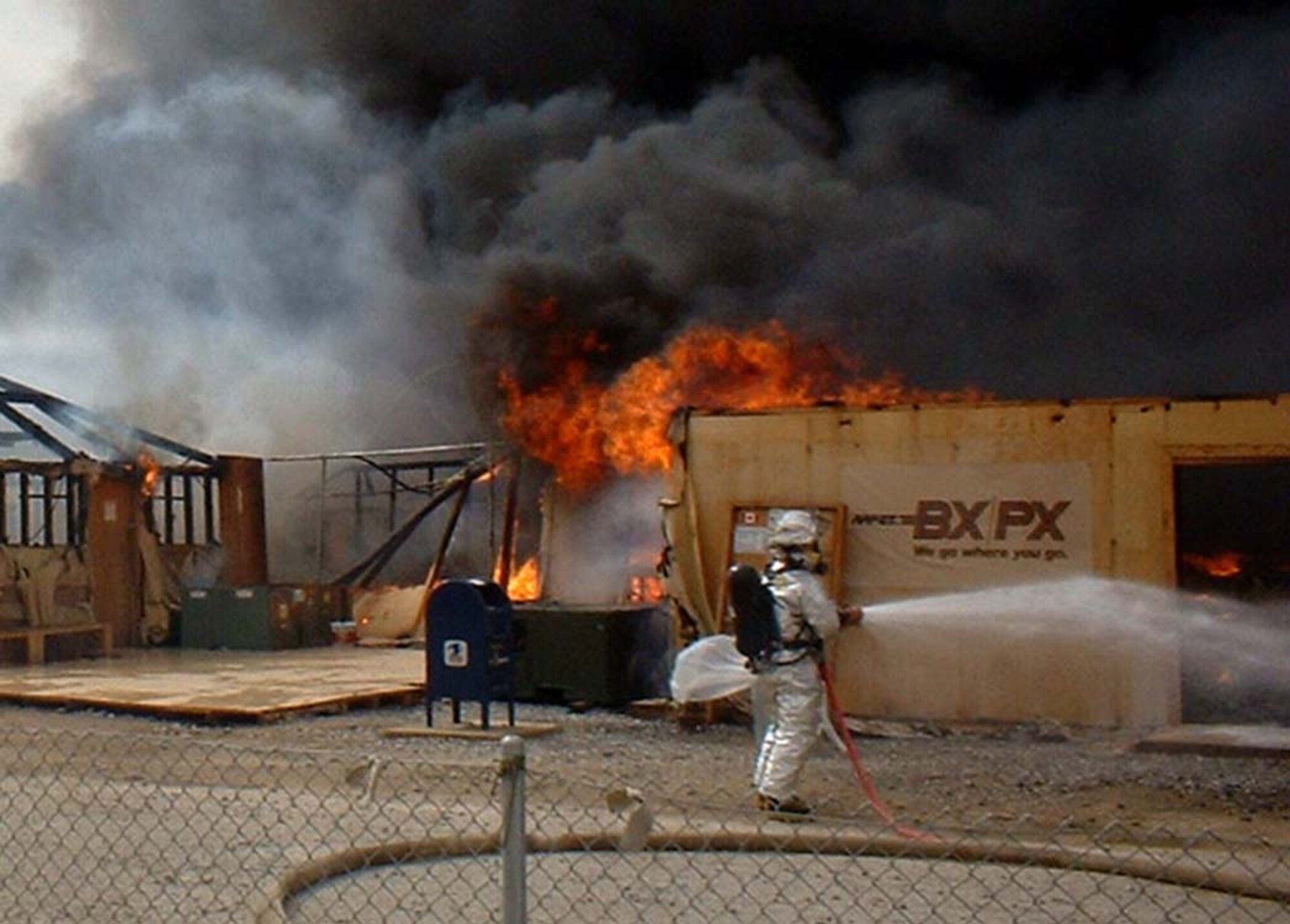 KANDAHAR, Afghanistan -- Air Force firefighters battle a blaze Feb. 21 that destroyed the exchange, barbershop, gift and coffee shop at Kandahar, Afghanistan. The blaze also destroyed the personal living quarters of 25 Army and Air Force Exchange Service employees. Damage costs are estimated at more than $1 million.  (U.S. Army photo by 1st Lt. Cory Angell)