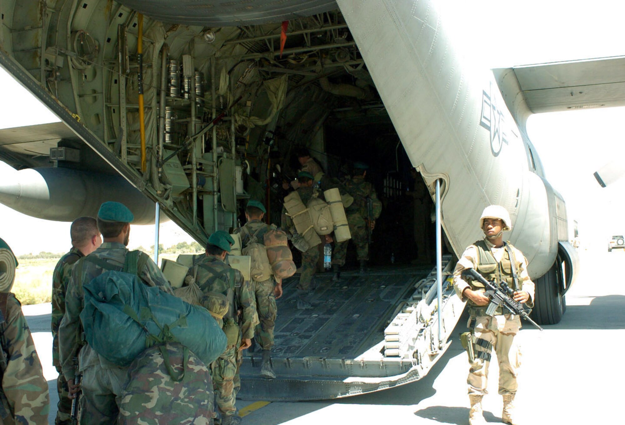 KABUL, Afghanistan -- Airman 1st Class Dontrell Lively provides security at Kabul International Airport here Aug. 15 as Afghan soldiers board a C-130 Hercules bound for Shindand National Airport.  The U.S. Air Force is helping airlift several Afghan battalions to Shindand to retake control of government property seized as a result of factional fighting in the area.  (U.S. Air Force photo by Master Sgt. Ann Bennett)