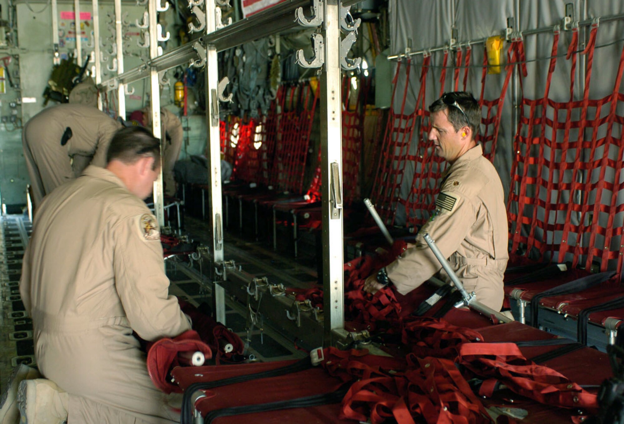 KABUL, Afghanistan -- Maj. Mitch McDonald (right) and his crew reconfigure their aircraft's cargo deck before moving Afghan soldiers Aug. 15 from Kabul International Airport to Shindand National Airport.  The Oklahoma Air National Guard aircraft and crew helped move 440 soldiers, 29 U.S. embedded training team advisers and eight Afghan interpreters from here to Shindand to retake control of government property seized as a result of factional fighting in the area.  Major McDonald is a C-130 Hercules aircraft commander.  (U.S. Air Force photo by Master Sgt. Ann Bennett)