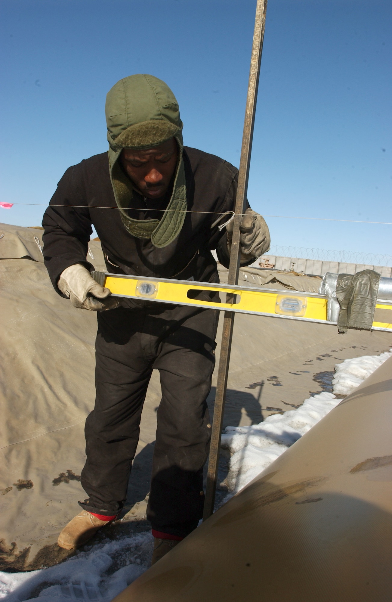 OPERATION ENDURING FREEDOM -- Airman 1st Class Karl Brown checks a fuel bladder to determine the quantity of fuel remaining at Ganci Air Base, Kyrgyzstan. Airmen from the 376th Logistics Readiness Squadron's petroleum, oil and lubricants flight are responsible for supplying fuel throughout the base.  (U.S. Air Force photo by Senior Airman Ashley Center)