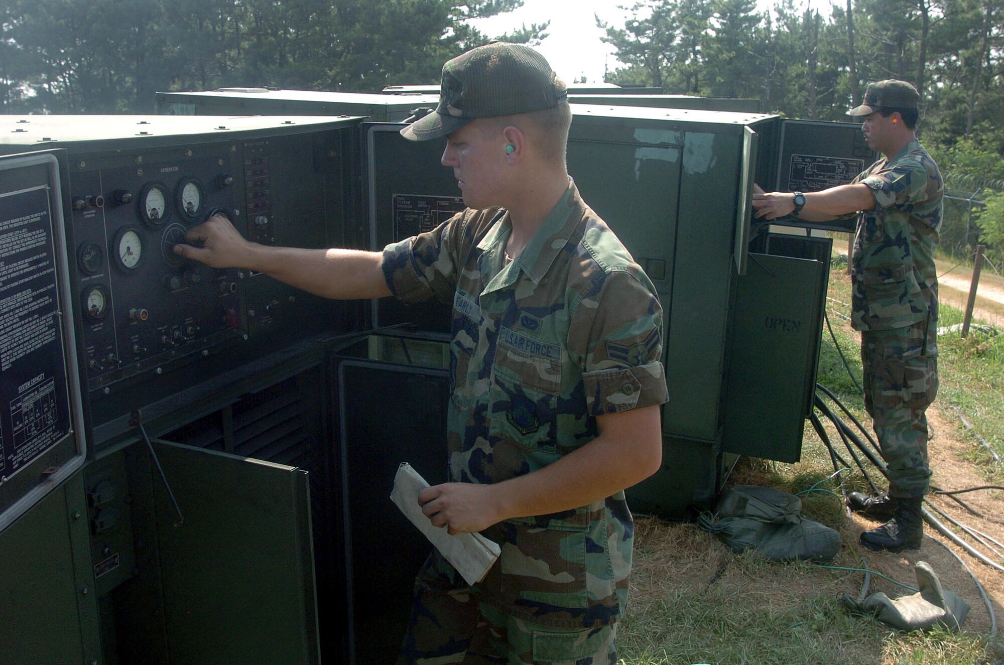 KUNSAN AIR BASE, South Korea -- Airman 1st Class David Early (foreground) and Senior Master Sgt. Manny Lapuz inspect a row of generators at tent city here.  They are assigned to the 8th Civil Engineer Squadron.  Civil engineers are providing a home for about 300 Airmen who are deployed here from the 49th Fighter Wing at Holloman Air Force Base, N.M.  (U.S. Air Force photo by Master Sgt. Val Gempis)