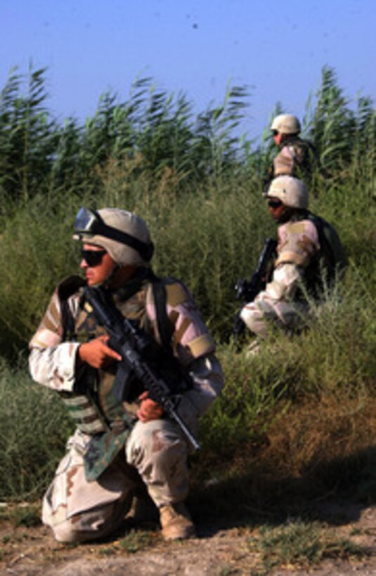 Soldiers from the 1st Infantry Division establish a security perimeter in the city of Baqubah, Iraq on Aug. 4, 2004, as other soldiers search for a crater from a rocket-propelled grenade recently launched towards Forward Operating Base Warhorse. The 1st Infantry Division is in Iraq supporting Operation Iraqi Freedom. 