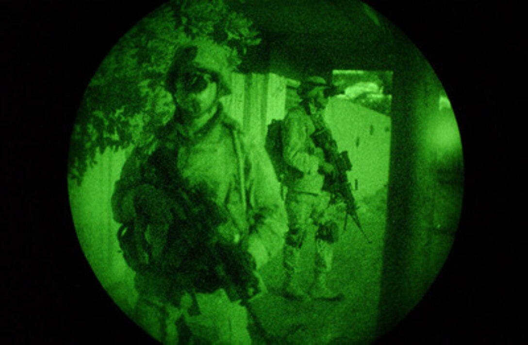 Two soldiers move methodically down a street during a night patrol of Bayji, Iraq, on Aug. 4, 2004. 