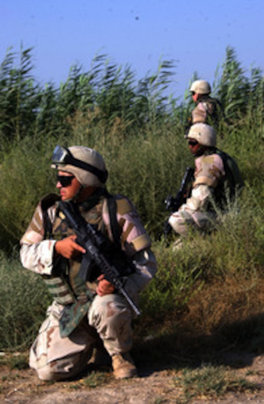 Soldiers from the 1st Infantry Division establish a security perimeter in the city of Baqubah, Iraq on Aug. 4, 2004, as other soldiers search for a crater from a rocket-propelled grenade recently launched towards Forward Operating Base Warhorse. The 1st Infantry Division is in Iraq supporting Operation Iraqi Freedom. 