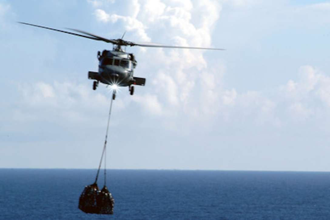 An HH-60H Seahawk transfers supplies to the USS Kitty Hawk (CV 63) during a replenishment-at-sea evolution on Aug. 6, 2004. Summer Pulse '04 is a U.S. Navy exercise where seven aircraft carrier strike groups will learn new ways of operating, training, manning and maintaining their fleet. This is part of the Navy's new Fleet Response Plan that will train the fleets to provide assistance in a national emergency or crisis. 