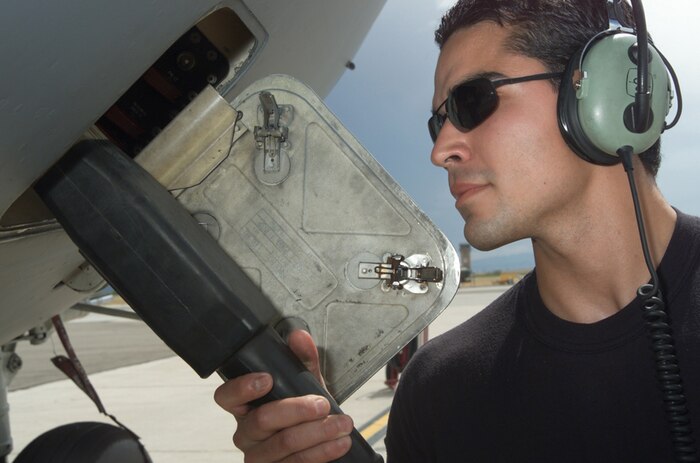 DAVIS-MONTHAN AIR FORCE BASE, Ariz. - Airman 1st Class Luis Robles attaches a battery to a C-17 Globemaster III here Aug. 13.  Airman Robles is assigned to the 437th Aircraft Maintenance Squadron at Charleston Air Force Base, S.C.  (U.S. Air Force photo by Staff Sgt. Lanie McNeal)
