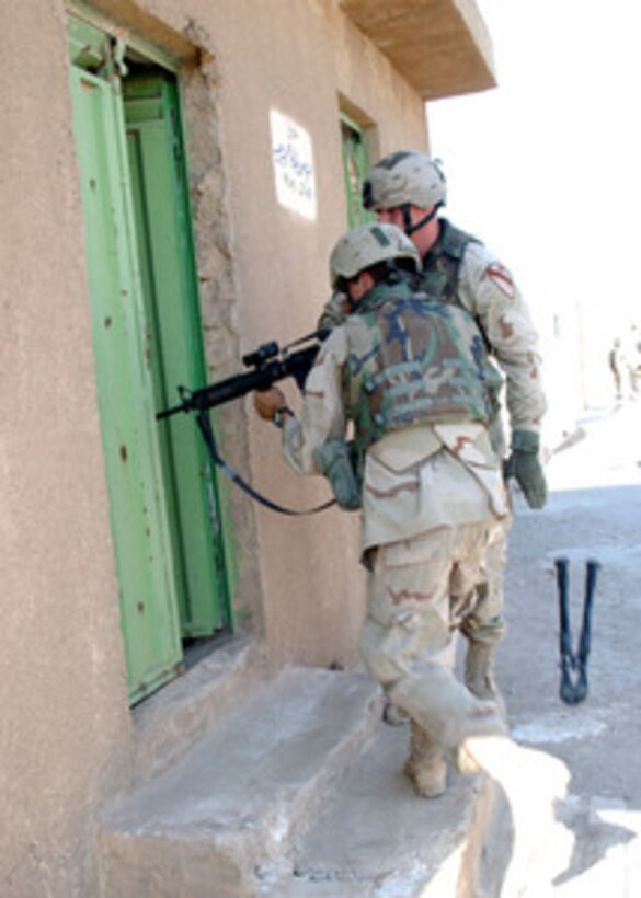 Two U.S. Army soldiers from B Company 1-5 Infantry of the 1st Cavalry Division prepare to search through the mausoleums, tombs and catacombs of the An Najaf cemetery on Aug. 08, 2004, for weapons caches, improvised explosive devices, and anti-Iraqi forces that might be hidden there. 