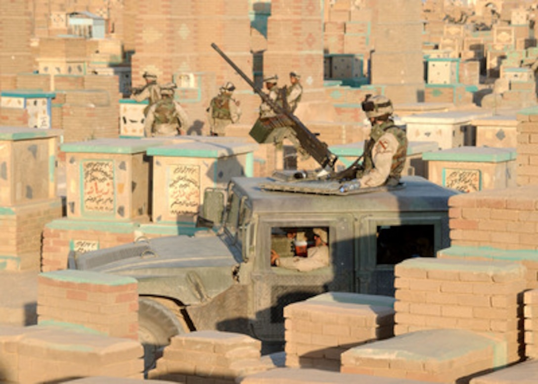 A U. S. Army soldier mans a .50 caliber machine gun atop a HUMVEE to provide cover fire for fellow soldiers during a search for weapons caches and insurgent forces in a cemetery near An Najaf, Iraq, on Aug. 10, 2004. 