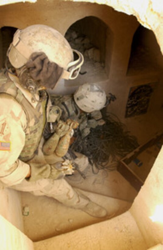 U.S. Army soldiers pull out mortar rounds, fuse-like items and car batteries hidden in a catacomb in the An Najaf Cemetery in Iraq, on Aug. 15, 2004. These items can be used to make improvised explosive devices. U.S. Army soldiers are searching through the mausoleums, tombs and catacombs of the An Najaf cemetery for weapons caches, improvised explosive devices, and anti-Iraqi forces that might be hiding there. 