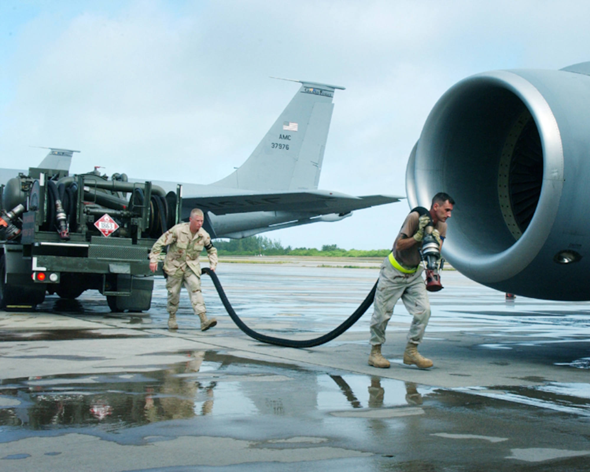OPERATION ENDURING FREEDOM -- Senior Airmen Michael Torbett (left) and Thomas Haefliger pull a servicing hose to refuel a KC-135 Stratotanker.  The fuels element Airmen here have issued more than 10 million gallons of aviation fuel.  Both Airmen are refueling unit operators with the 40th Expeditionary Logistics Readiness Flight fuels element.  They are deployed from Fairchild Air Force Base, Wash.  (U.S. Air Force photo by Master Sgt. Sean Brennan)
