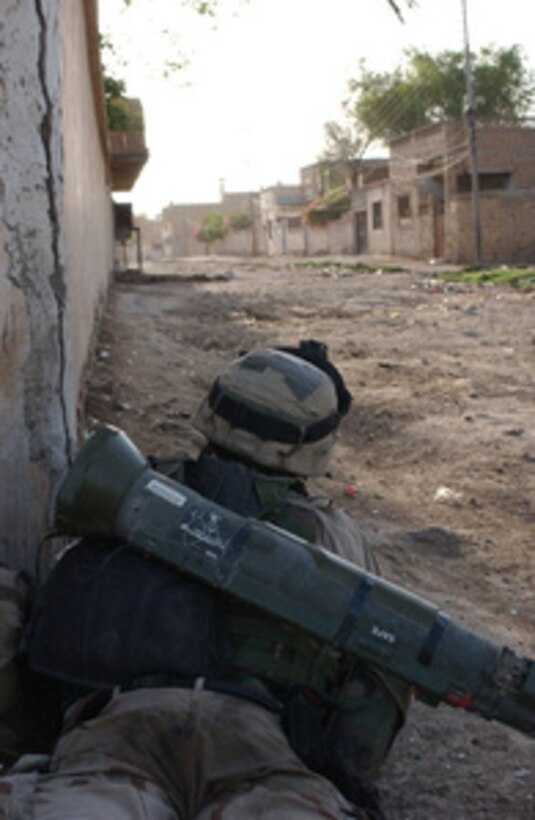 A U.S. Army soldier watches a deserted street during combat operations to extract insurgents and illegal weapons in Al Hayy of the Wasit province in Iraq on Aug. 17, 2004. 