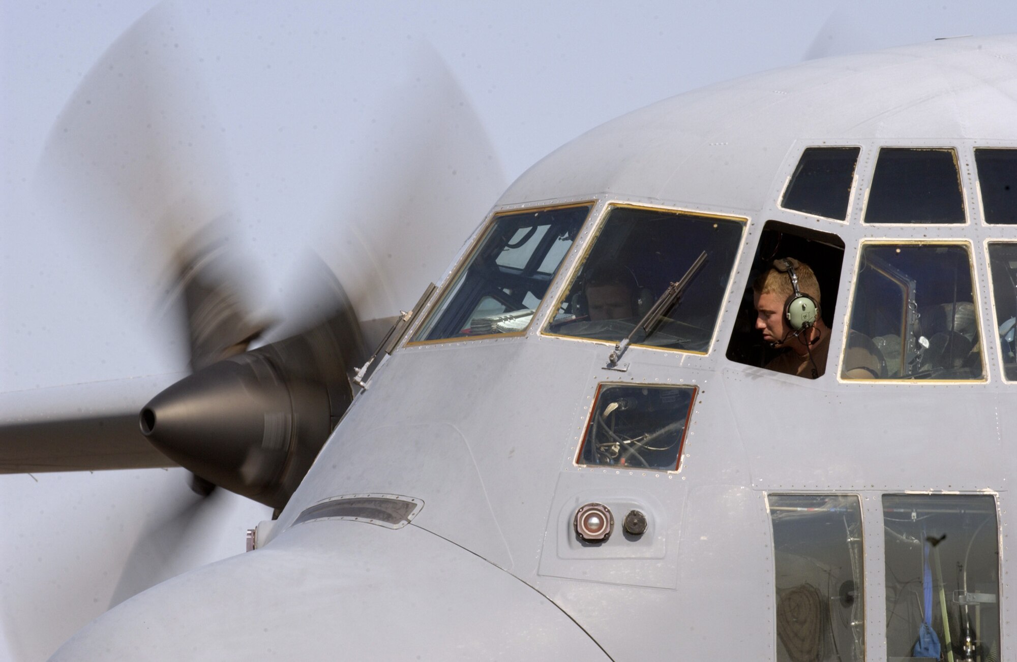 MANAS AIR BASE, Kyrgyzstan -- Airman 1st Class Alex O'Donnell and Senior Airman Derek Smith climb into a C-130 Hercules flight deck to fire up the engine and watch for changes in the gauges.  They are aircraft maintainers assigned to the 376th Expeditionary Air Maintenance Squadron and are deployed from Little Rock Air Force Base, Ark.  (U.S. Air Force photo by Master Sgt. Scott Wagers)
