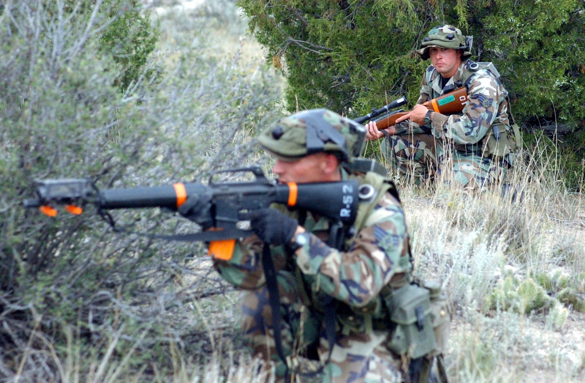 CAMP GUERNSEY, Wyo. -- Senior Airman Matthew James (left) returns fire as Senior Airman Landon Elledge watches his back during the Road Warrior III exercise here.  They are assigned to the 791st Missile Security Forces Squadron at Minot Air Force Base, N.D.  (U.S. Air Force photo by Master Sgt. Jeff Bohn)