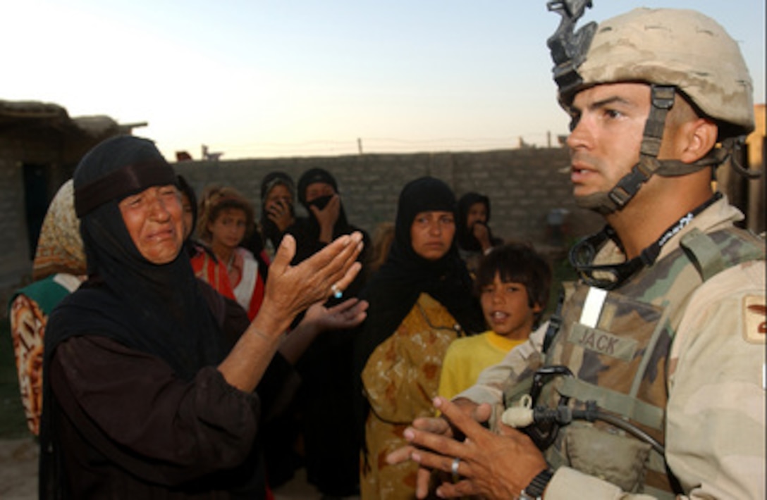 The mother of an Iraqi man taken into custody during Operation Grizzly Forced Entry on Aug. 21, 2004, pleads with Army Lt. Jim Jack to release her son. Operation Grizzly Forced Entry is a cordon, search and seizure mission to capture high value targets who have launched attacks against coalition forces. 
