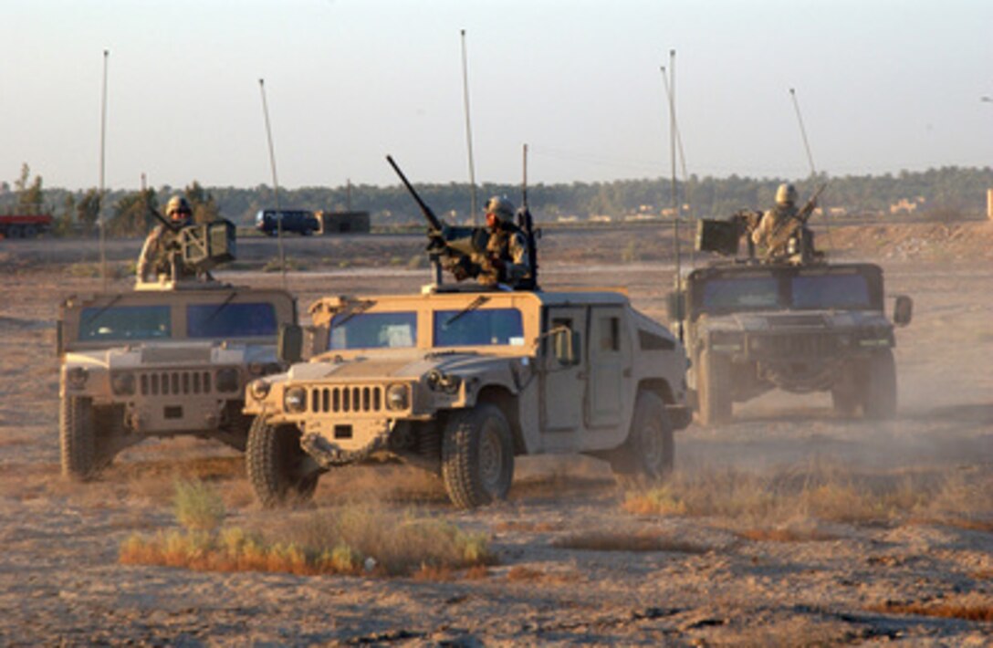 U.S. Army soldiers of the 1st Infantry Division position their Humvees near a house they are clearing to use as an observation point outside Baqubah, Iraq, on Aug. 19, 2004. 