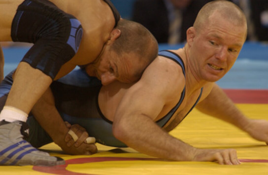 U.S. Army Sgt. Oscar Wood (right) wrestles Jannis Zamanduridis from Germany in the second pool round of the 66kg Greco-Roman wrestling at Ano Liossia Olympic Hall during the 2004 Olympics in Athens, Greece, on Aug. 24, 2004. Wood from Fort Carson, Colo., lost to Zamanduridis 5-2 and did not move past the pool round to qualify for the semi-finals. 
