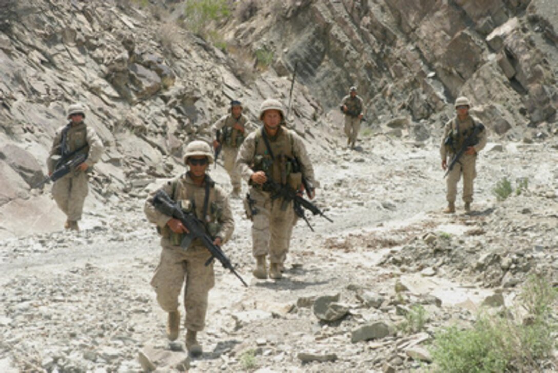 U.S. Marines patrol through a dry creek bed while they search caves in Khowst, Afghanistan, on Aug. 18, 2004. The Marines are currently conducting vehicle checkpoints and village assessments while maintaining an offensive presence throughout the region in support of Operation Enduring Freedom. 