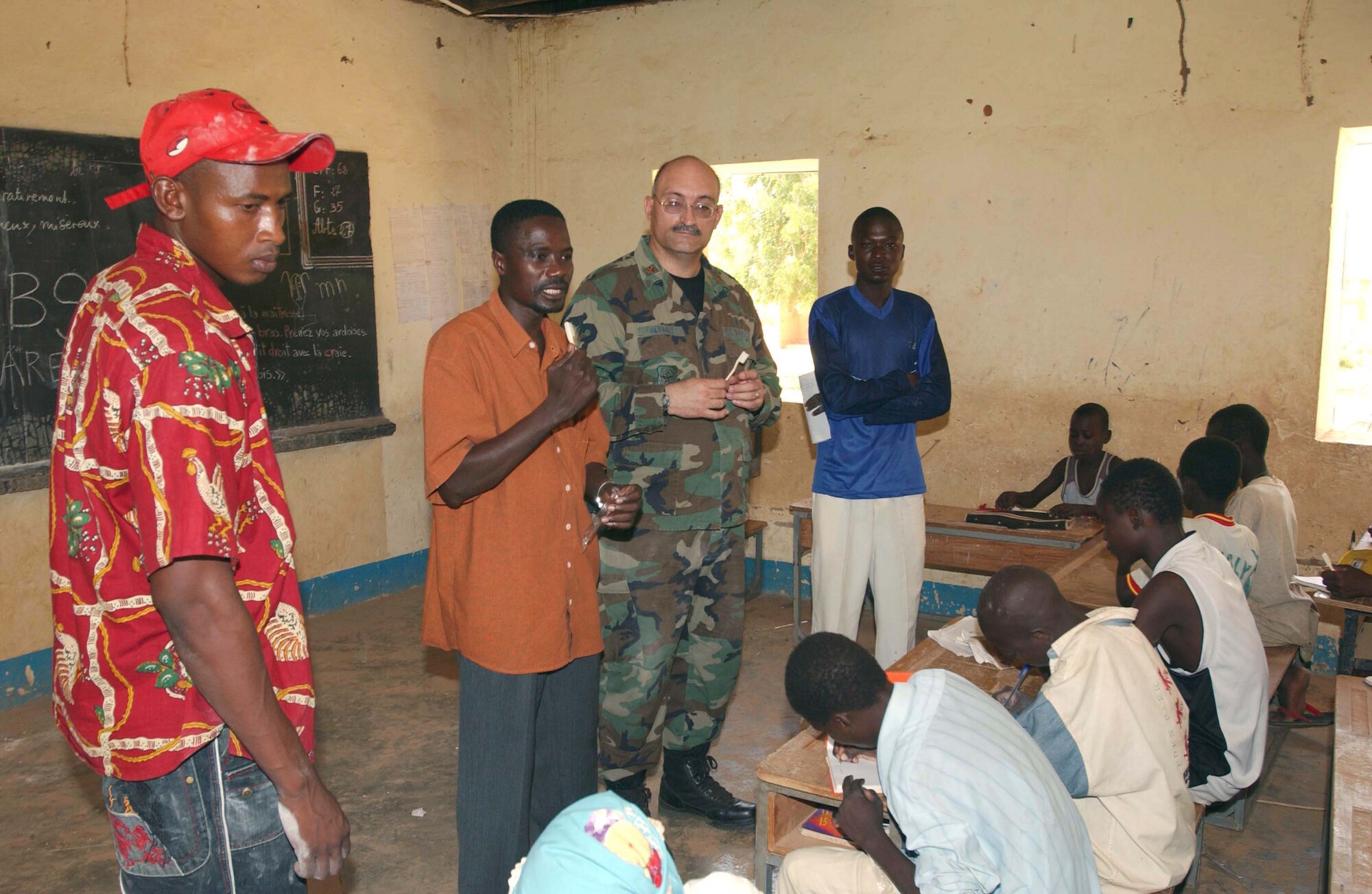 NEAR CAMP TONDIBIAH, Niger -- Maj. (Dr.) Joe Alvarez and translator Hamadou Soumana demonstrate the proper use of a toothbrush at a local school.  Dr. Alvarez was part of an Air Force Reserve humanitarian mission in Niger.  He is a dentist with the 445th Aeromedical Staging Squadron at Wright Patterson Air Force Base, Ohio.  (U.S. Air Force photo by Tech. Sgt. Chance Babin)