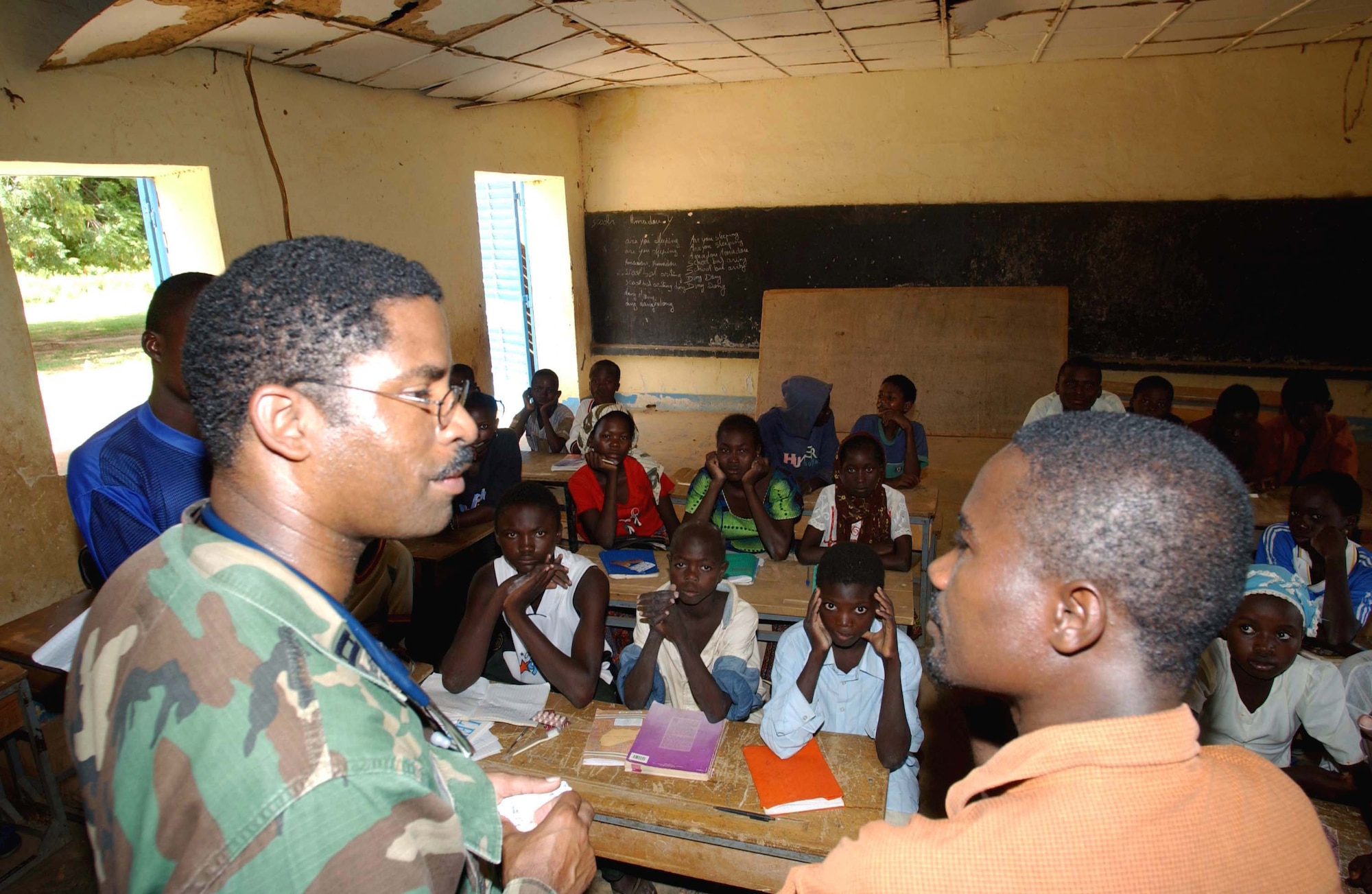 NEAR CAMP TONDIBIAH, Niger -- Capt. Andrew Gibson and translator Hamadou Soumana discus health care and hygiene to a group of students at a local school.  Captain Gibson was part of an Air Force Reserve humanitarian mission in Niger.  He is a physician's assistant with the 6th Medical Group at MacDill Air Force Base, Fla.  (U.S. Air Force photo by Tech. Sgt. Chance Babin)