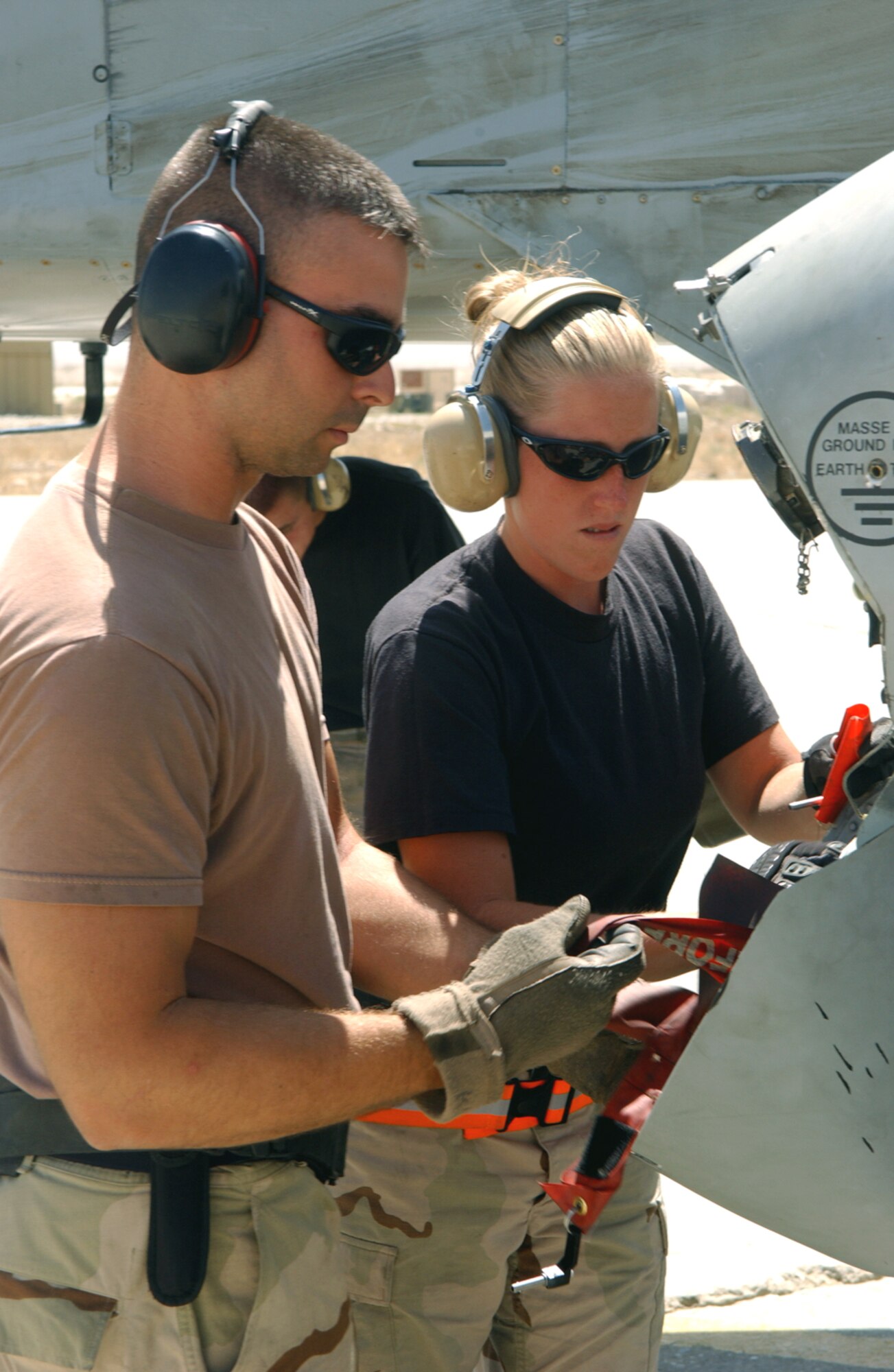 BAGRAM AIR BASE, Afghanistan -- Staff Sgt. Nathaniel Kibodeaux (left) and Airman 1st Class Stacy Wilson remove weapons pins from an A-10 Thunderbolt II storage compartment.  They are assigned to the 354th Expeditionary Aircraft Maintenance Squadron.  (U.S. Air Force photo by Master Sgt. Andrew Gates)
