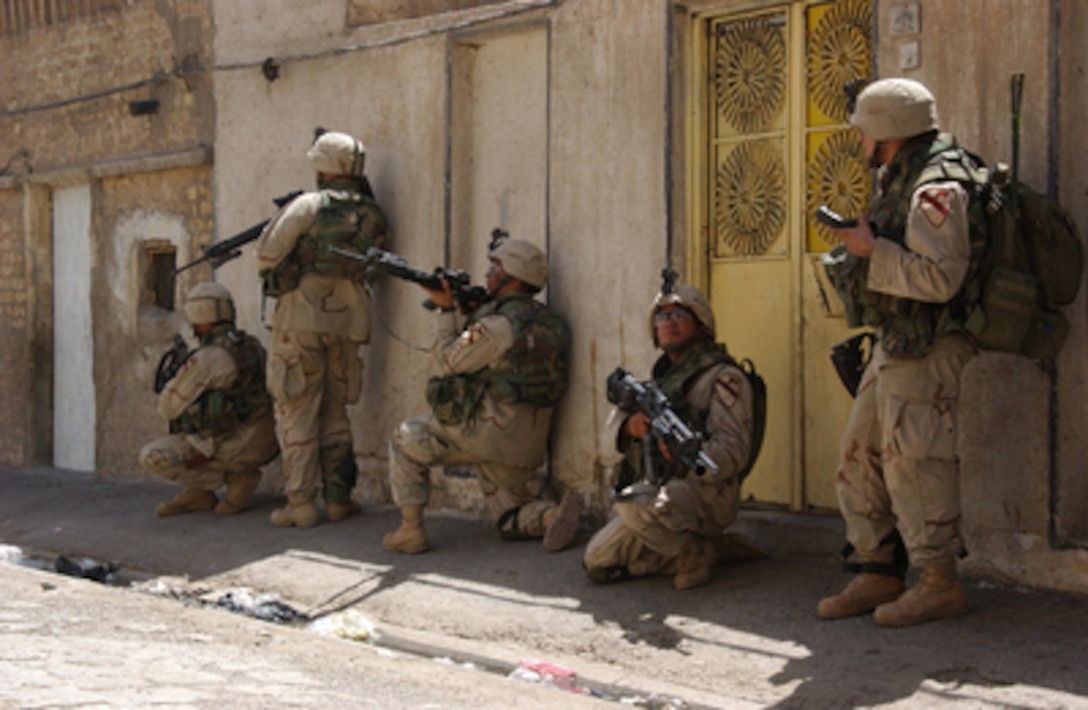 U.S. Army soldiers remain alert as they clear alleyways in Sadr City, Iraq, on Aug. 18, 2004. The 5th Cavalry Regiment is supporting Operation Iron Fury in an attempt to maintain stability in the Sadr City region. 