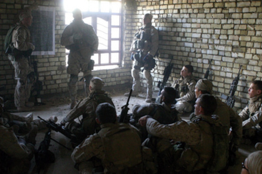 U.S. Marine Corps Sgt. Chambers briefs other Marines on the day's schedule in Fallujah, Iraq, on Nov. 11, 2004. The Marines, assigned to Regimental Combat Team Seven, 1st Battalion, 3rd Charlie Company, are preparing to clear the houses surrounding their current position inside the city of Fallujah. 