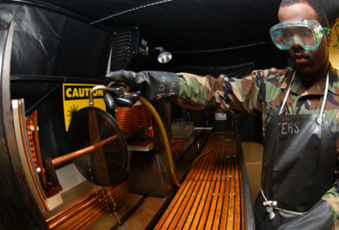 U.S. Air Force Airman 1st Class Michael Walters uses a magnetic particle machine to magnetize aircraft parts in order to detect defects under florescent lighting at Aviano Air Base, Italy, on Nov. 18, 2004. Walters is a non-destructive inspector assigned to the 31st Maintenance Squadron. Non-destructive inspectors perform critical inspections on aircraft parts and make recommendations to other maintenance personnel. 
