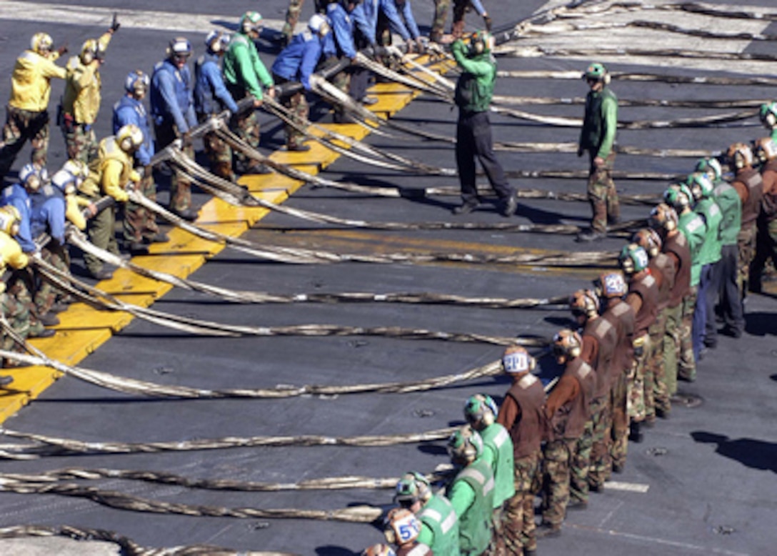 Crewmembers aboard the aircraft carrier USS Abraham Lincoln (CVN 72) prepare to rig the emergency-landing barricade during a flight deck drill as the ship operates in the western Pacific on Nov. 18, 2004. The barricade can be quickly rigged and raised across a carrier's flight deck to catch an aircraft experiencing a landing gear or tailhook malfunction. 