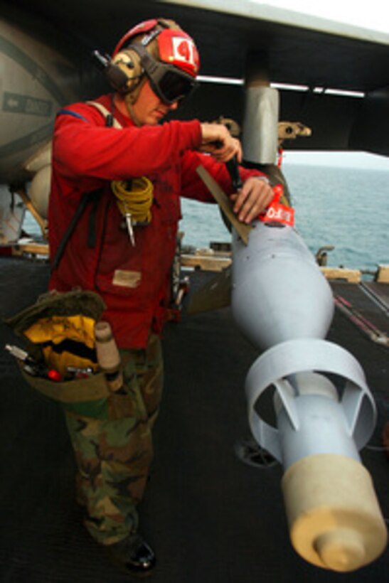 Petty Officer 3rd class Joshua Silva attaches a stabilizer fin to a GBU-16 Paveway II 1,000-pound laser guided bomb loaded on an F/A-18C Hornet aboard the aircraft carrier USS Harry S. Truman (CVN 75) underway in the Persian Gulf on Nov. 19, 2004. Silva serves as an aviation ordnanceman assigned to Strike Fighter Squadron 105. 